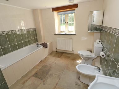 A bathroom with a bathtub, toilet, bidet and sink at Carreg Las in Haverfordwest