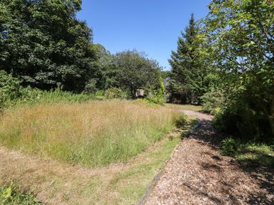 A garden area with a pathway and trees at Carreg Las Haverfordwest