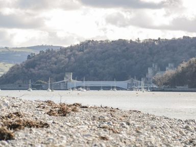 A view of a river with boats and a bridge at Flat 1A, Mona House in Conwy
