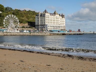 A beach with a hotel and ferris wheel at Flat 1A, Mona House Conwy