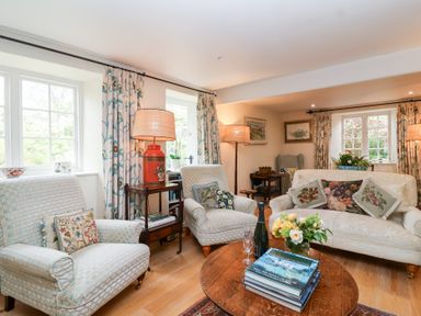 A living room with sofa and armchairs at Magdalen Cottage Hook Norton