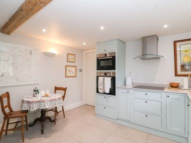 A kitchen with a table and chairs at Magdalen Cottage in Hook Norton