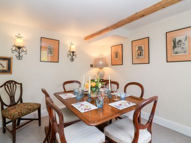 A dining room with a table and chairs at Magdalen Cottage, Hook Norton