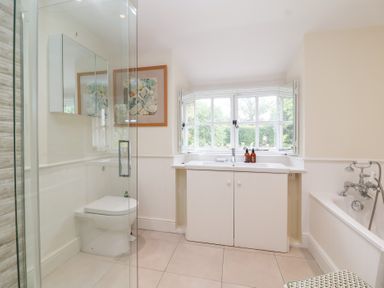 A bathroom with a shower, bathtub, and sink at Magdalen Cottage in Hook Norton