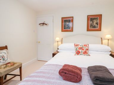 A bedroom with a bed and two bedside lamps at Magdalen Cottage in Hook Norton