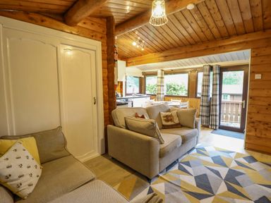 A living room with a sofa and table at Swn Yr Afon - No 333