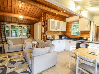 A living room with a sofa and dining area at Swn Yr Afon - No 333