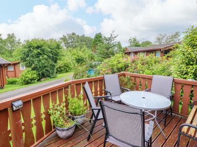 A deck with a table and chairs at Swn Yr Afon - No 333