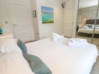 A bedroom with a bed and towels at Lodge 83, Gwel an Mor, Portreath