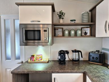 A kitchen with microwave, coffee maker, kettle and toast at Fernwood Lodge in Fritton near Belton, Norfolk