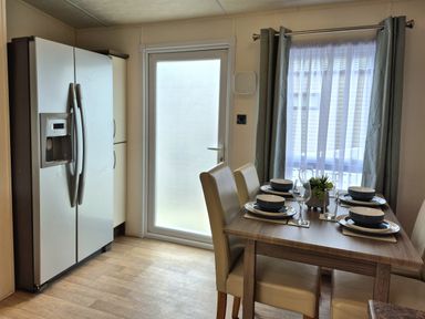 A kitchen with a table set for dining at Fernwood Lodge in Fritton near Belton, Norfolk