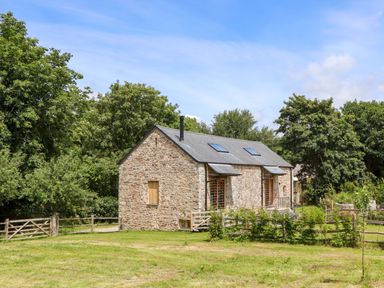 A stone house with a grassy area at Lower Walreddon Barn Tavistock