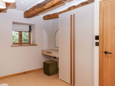 A bedroom with a window and wardrobe at Lower Walreddon Barn Tavistock