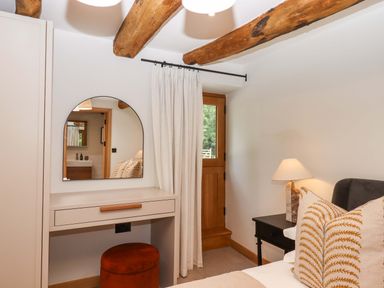 A bedroom with a mirror and desk at Lower Walreddon Barn Tavistock