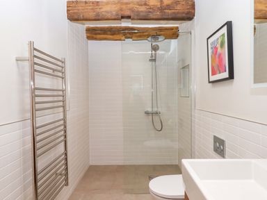 A bathroom with a shower and towel rail at Lower Walreddon Barn in Tavistock