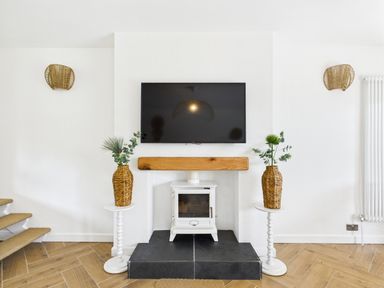 A living room with a television and fireplace at 59a Gwscwm Road