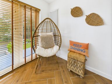 A snug with a hanging chair and decorative pillows at 59a Gwscwm Road 