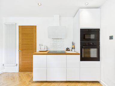 A kitchen with appliances and a door at 59a Gwscwm Road