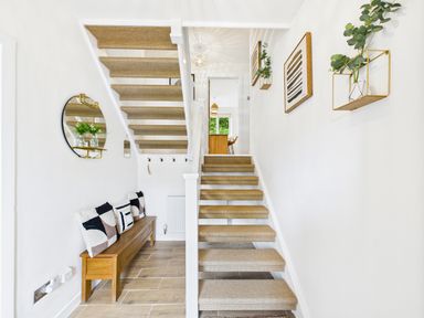 A hallway with stairs and a bench at 59a Gwscwm Road