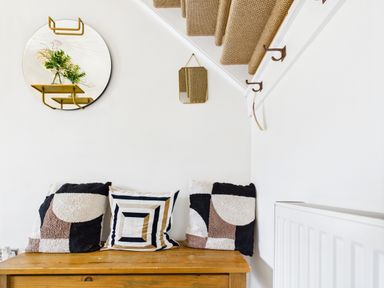 A hallway with a wooden bench and cushions at 59a Gwscwm Road