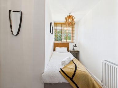 A bedroom with a single bed, nightstand, and window at 59a Gwscwm Road