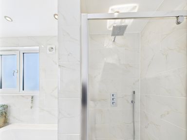 A bathroom with a shower and bathtub at 59a Gwscwm Road