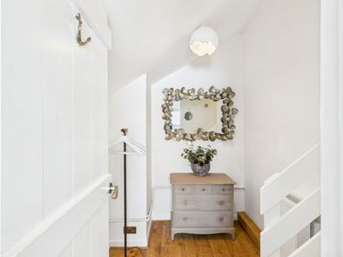 A hallway with a dresser and mirror at 59a Gwscwm Road
