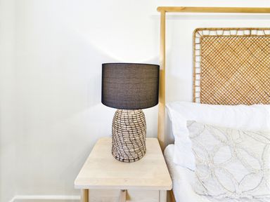 A lamp on a nightstand beside a bed at 59a Gwscwm Road