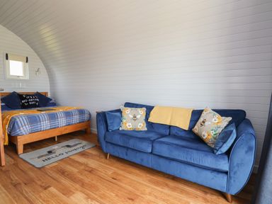A bedroom with a bed and sofa at Honeypot Hideaways - Manuka