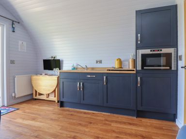 A kitchen with a sink and microwave at Honeypot Hideaways - Clover