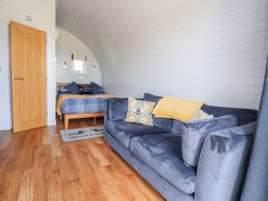 A bedroom with a bed and sofa at Honeypot Hideaways - Clover