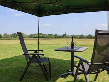A seating area with a table and drinks under a tent at Honeypot Hideaways - Clover