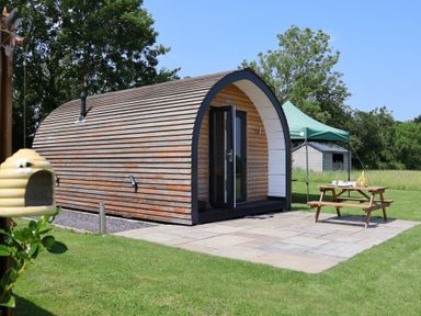 A cabin with a patio and a tent at Honeypot Hideaways - Clover