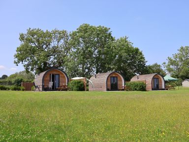 Three cabins with seating in an outdoor area at Honeypot Hideaways - Clover