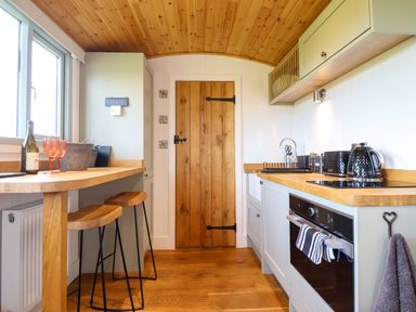 A kitchen with a countertop and stools at Charollais Oswestry
