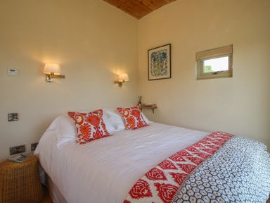 A bedroom with a double bed and wall art at Owl's Hollow Chapel Lawn near Clun