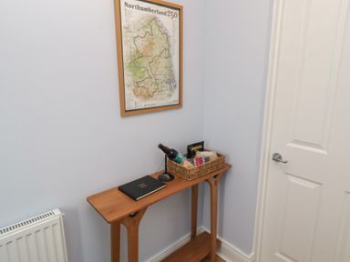 A hallway with a table and a map at Linn Cottage in Hexham