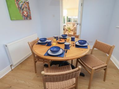 A dining room with a table set for breakfast at Linn Cottage in Hexham