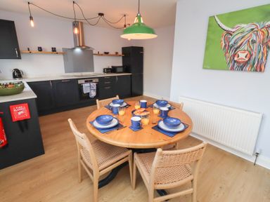 A kitchen with a round table set for dining at Linn Cottage in Hexham