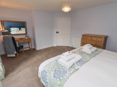 A bedroom with bed and towels at Linn Cottage in Hexham