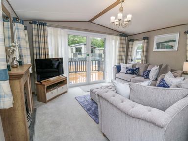 A living room with a sofa and television at The Beaumont No 34 in New Quay