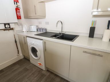 A kitchen with a washing machine and sink at Harbour View in Whitehaven