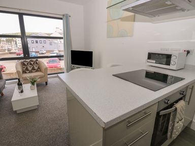 A living room with a kitchen area and sofa at Harbour View in Whitehaven