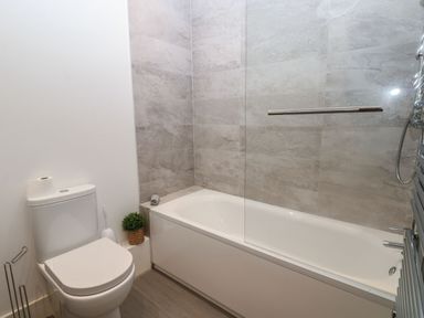 A bathroom with a bathtub and toilet at Harbour View in Whitehaven