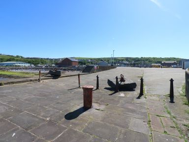 An outdoor area with an anchor and bollards at Harbour View in Whitehaven