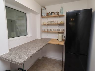 A kitchen with a countertop and a refrigerator at Bari House in Seahouses