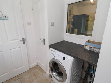 A laundry room with a washing machine and countertop at Bari House in Seahouses