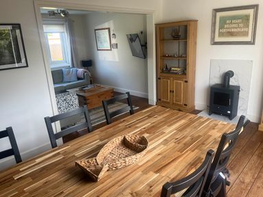 A dining room with a wooden table and chairs at Bari House in Seahouses