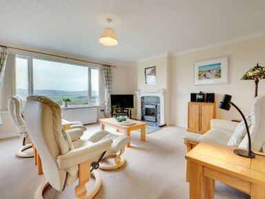 A living room with furniture and large windows at The Granary in Alnwick