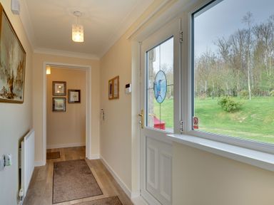 A hallway with a door and window at The Granary in Alnwick